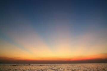 Ray of sunlight, crepuscular rays, in summer time with the clouds, the sea, and the island. Low key. Nature background concept.