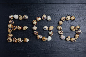 fresh quail eggs on the dark wooden background.