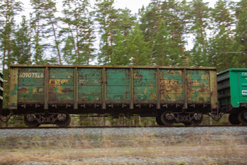 Fototapeta na wymiar A gondola car as part of a train. A gondola car as part of a freight train rushes along the rails.