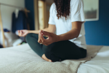 Frau macht Yoga und Dehnübungen zur Entspannung zuhause auf dem Bett