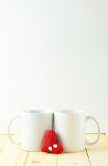 Two white mugs together with a heart in the center.