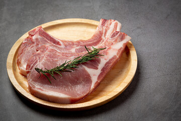 raw pork chop steak on the dark background.