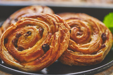 Close up of Sweet cinnamon roll cake with raisins filling served on the black plate