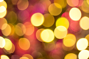 Yellow, red and orange glitter -- abstract festive elegant background with blurred bokeh lights. Defocused holiday lighting.
