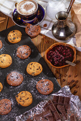 Cookies with chocolate, jam and coffee on a wooden table, flat lay, top view