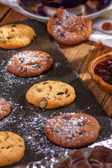 Cookies with chocolate, jam and coffee on a wooden table, flat lay, top view