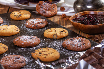 Cookies with chocolate, jam and coffee on a wooden table, flat lay, top view
