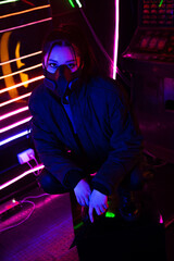 Fototapeta na wymiar neon lighting on young asian woman in gas mask