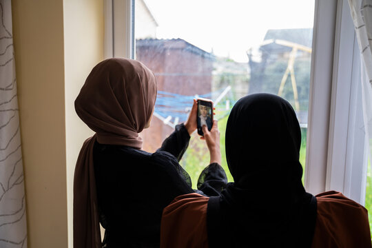 Two Black Muslim sisters taking selfies