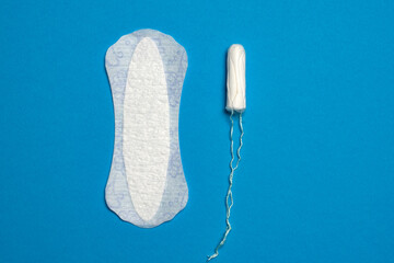 Sanitary pad and a menstrual tampon isolated on blue background. 