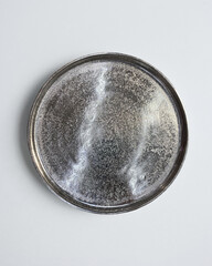 New luxury cutlery view from above on a isolated white background. Top view. Silver saucer. Trendy plate pastel shades. Flat lay view.