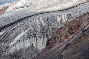 Fragment of Maly Azau glacier on the Elbrus volcano. Southwest side of Mount Elbrus. Deep cracks are visible on the surface of the glacier. Altitude 3500 m. July 2020