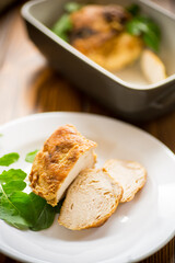 baked chicken fillet pieces with spices and herbs, in a ceramic form