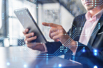 Businessman in suit using tablet device to optimize development by implying new technologies in...