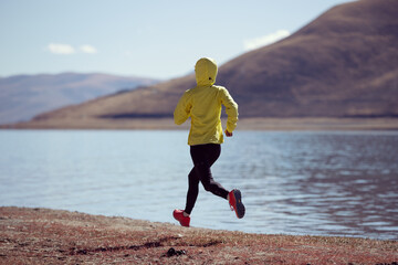 Woman trail runner cross country running  in winter lakeside