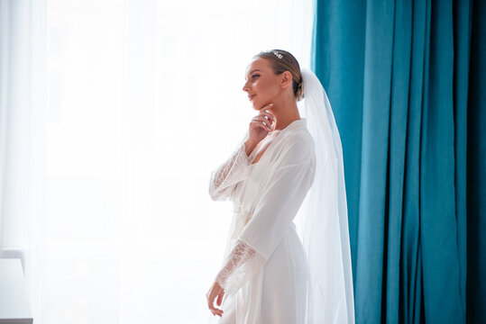 Happy bride in lingeria looking at mirror