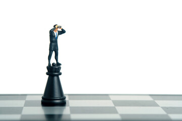 Businessman using binoculars standing above fortress castle chess pawn. Miniature tiny people toys photography. isolated on white background