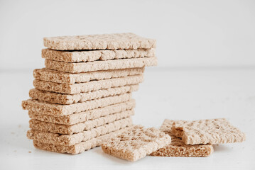Stacked rye crisp bread on a white wooden background. Copy, empty space for text