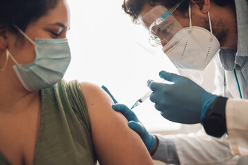 Doctor doing the covid-19 vaccination at home of a woman