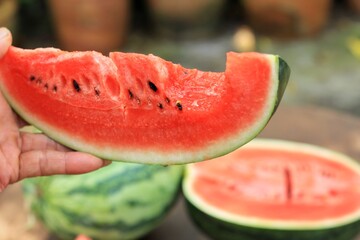 Closeup at Asian's hand is showing bitten watermelon after eating.Very Juicy and Low calories.Good for dieting and lose some weight.Fruit and healthy concept.