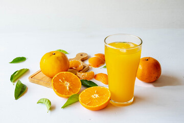 Freshly squeezed orange juice and orange fruit cut in half