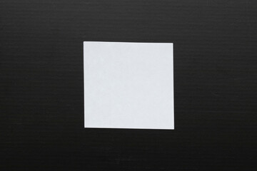White sheet of paper on black cardboard. 