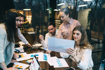 Coworkers at table with laptop and documents