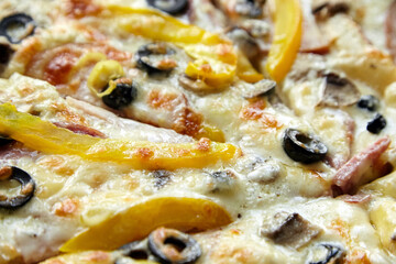 Pizza slices with chesse, ham, yellow bell pepper, olives and mushrooms, background , closeup