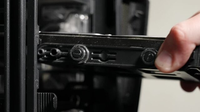 Closeup view 4k stock video footage of male hand removes and inserts old dusty hdd (hard drive disks) into computer case