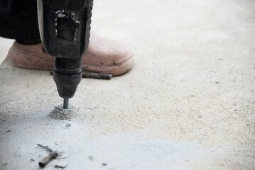 Construction worker doing his job - drilling concrete floor