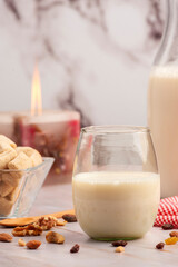 Milk bottle with glass and fiber cereals and nuts, on a marble tabletop and squared napkin, healthy and healthy breakfast and snack.