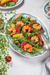 salad with shrimps, arugula, tomatoes and citrus fruits