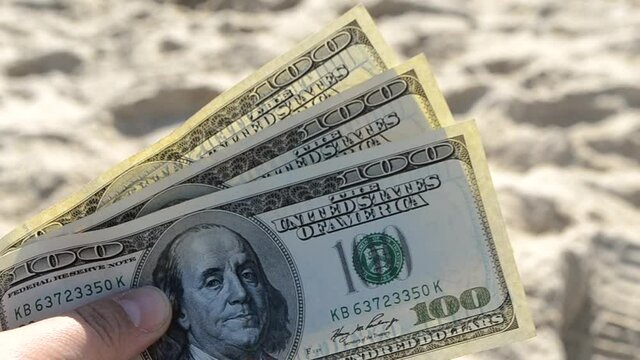Dollar bills on background of sea on sunny day close-up.