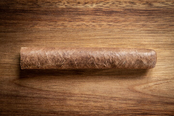 Brown cuban cigar on wooden background
