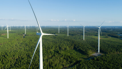 Top view of a modern windmill against a blue sky. The white blades of the wind turbine. Wind...