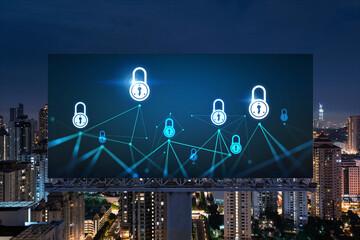 Padlock icon hologram on road billboard over panorama city view of Kuala Lumpur at night to protect business, Malaysia, Asia. The concept of information security shields.