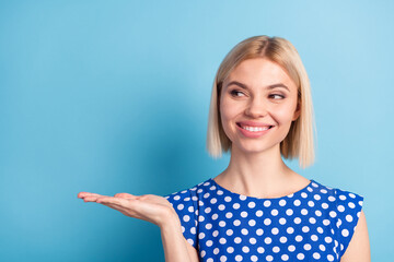 Photo of young girl happy positive smile look present product offer advert suggest isolated over blue color background