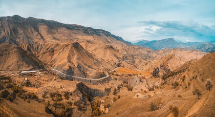 Panorama of a mountain valley with a serpentine road.