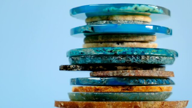 Agate stone slices.Blue and brown agates on a blue background. Stack of agate close-up. Rotation.