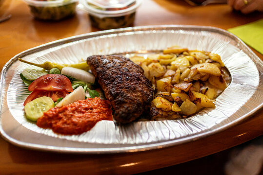 Food to go: stuffed meatloaf with broad potatoes, onions an ajvar on an aluminium dish