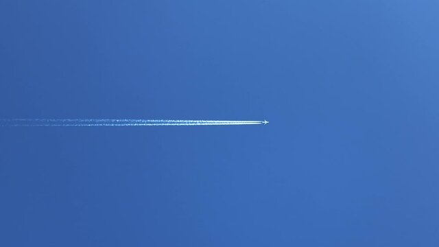 Jet aeroplane flying directly overhead with vapor trails  
