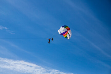 parachuye flight in fine weather against the background of a blue sky with small clouds