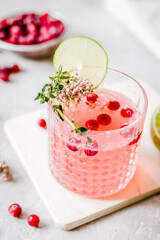 fresh homemade drink with berries and lime on kitchen background
