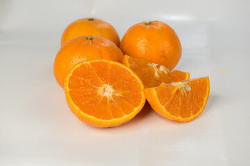 a capped fresh mandarin orange on white background