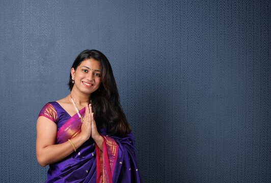 indian woman in welcome pose with both hands folded in namaskara or prayer gesture.