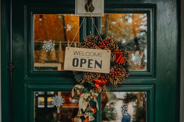 welcome open. sign board through the glass of store window.