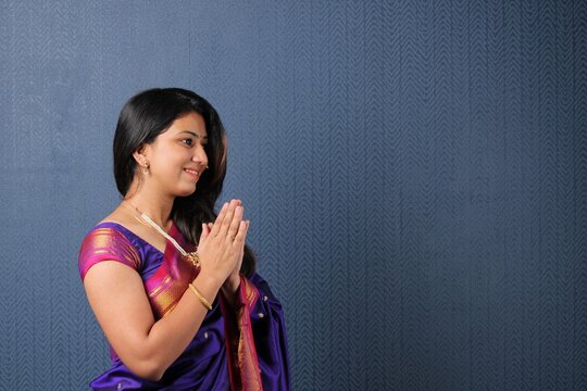 indian woman in welcome pose with both hands folded in namaskara or prayer gesture.