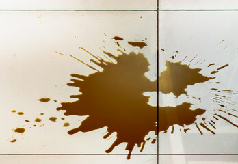Fototapeta na wymiar Fresh spilled black coffee from mug on the Tile floor. Empty place for text. Selective focus
