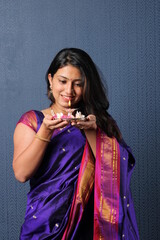 Indian Girl or women holding Pooja Thali offering applying tika