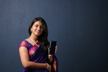 Advertisement concept - Pretty Indian young woman showing smartphone or mobile blank screen 